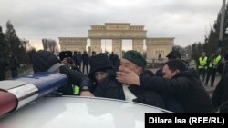 Үкіметке қарсы шеру өтетін жерде ұсталған адамды полиция көлікке күштеп салып жатыр. Шымкент, 22 ақпан 2020 жыл.