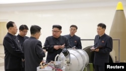 Кем Чен Ын (в центре) дает указания о развитии ядерной программы. Фото официально распространено в КНДР 3 сентября 