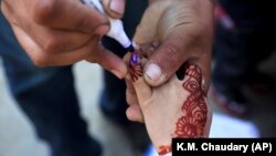 A health worker marks the finger of a child who just received the polio vaccine in Lahore on February 18, shortly before the nation shifted gears to fight the coronavirus pandemic.