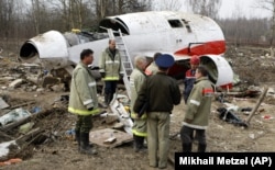 A sürgősségi minisztérium munkatársai a Lech Kaczyński lengyel elnök halálát okozó repülőgép-szerencsétlenség helyszínén, Szmolenszkben a roncsok mellett 2010. április 13-án