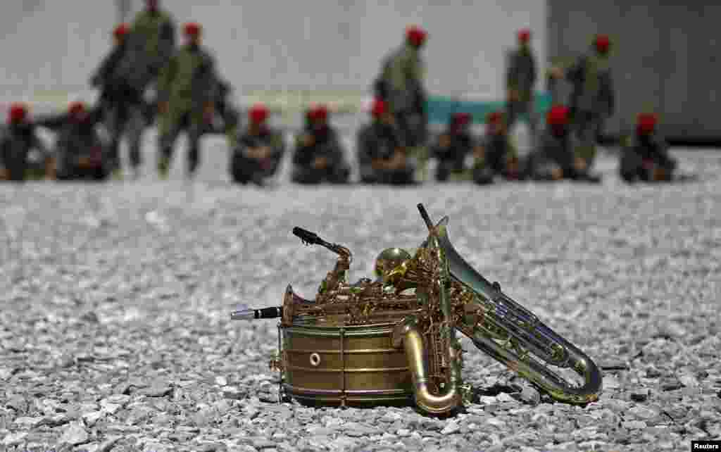 Musical instruments lie on the ground in front of members of the military during a ceremony to hand over the Bagram prison to Afghan authorities at the U.S. air base at Bagram. (Reuters/Mohammad Ismail)