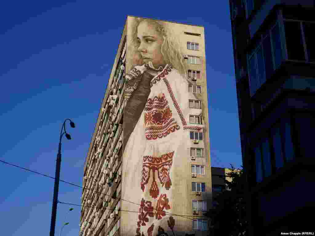 Portrait of a girl wrapped in traditional Ukrainian clothing, by Australian artist Guido van Helten. The mural covers 18 stories of a Soviet-era apartment block.&nbsp;