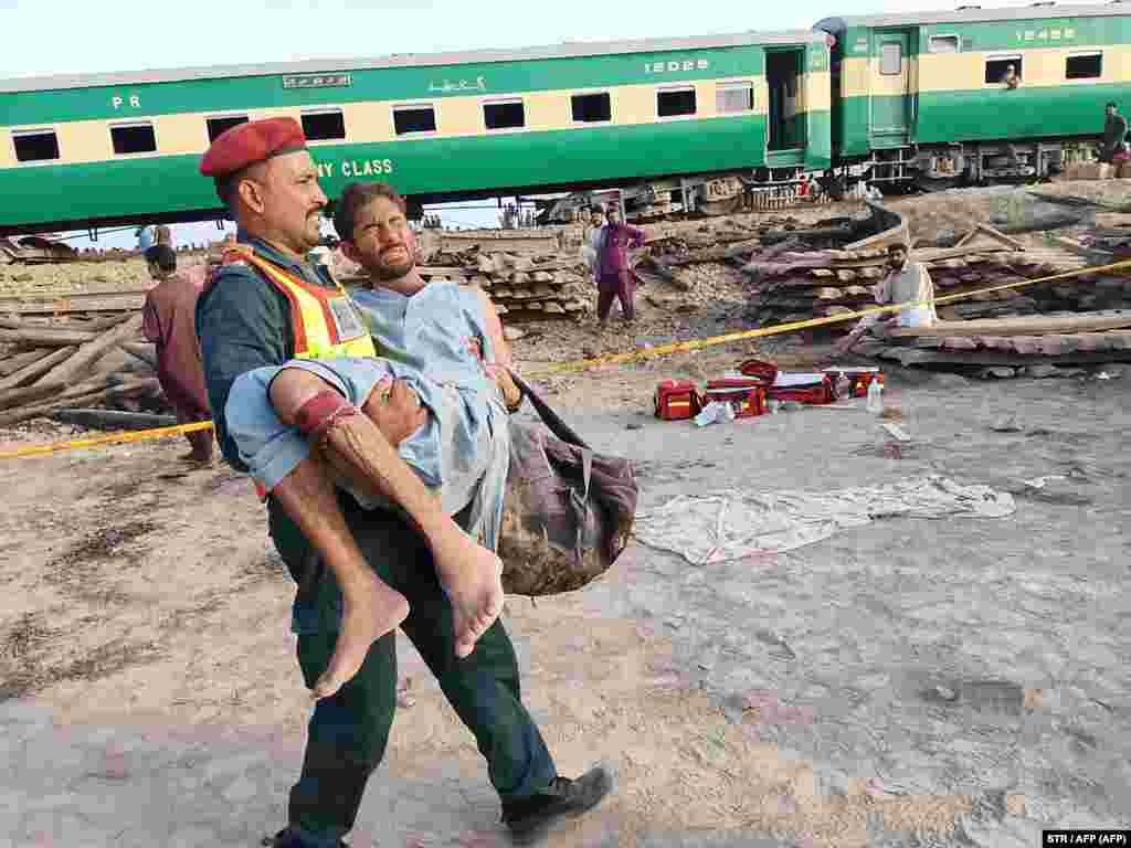 A Pakistani rescuer carries an injured passenger at the site of train accident&nbsp;