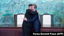 North Korean leader Kim Jong Un (left) and South Korean President Moon Jae-in hug during a signing ceremony near the end of their historic summit in the truce village of Panmunjom on April 27. The leaders embraced warmly after signing a statement in which they declared "there will be no more war on the Korean Peninsula." (AFP/Korea Summit Press Pool)