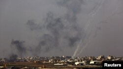 Посеред диму від ізраїльських ударів палестинці продовжують запускати по Ізраїлеві свої ракети, сліди яких тягнуться з пускових установок серед житлових кварталів. Центральна частина Смуги Гази, 19 листопада 2012 року