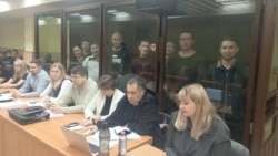 Обвиняемые за стеклом. Слева направо: Альфинур Рахматуллина, Юлай Аюпов, Салават Елкибаев, Самат Давлетов, Ахмет Якупов, Артур Мухаметов, Закир Ахмедин, Ильяс Байгускаров. Фото: Telegram-канал "Байгускар"