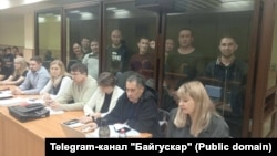 Обвиняемые за стеклом. Слева направо: Альфинур Рахматуллина, Юлай Аюпов, Салават Елкибаев, Самат Давлетов, Ахмет Якупов, Артур Мухаметов, Закир Ахмедин, Ильяс Байгускаров. Фото: Telegram-канал "Байгускар"