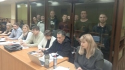 Обвиняемые за стеклом. Слева направо: Альфинур Рахматуллина, Юлай Аюпов, Салават Елкибаев, Самат Давлетов, Ахмет Якупов, Артур Мухаметов, Закир Ахмедин, Ильяс Байгускаров. Фото: Telegram-канал "Байгускар"