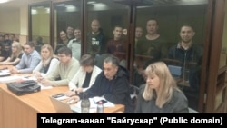 Обвиняемые за стеклом. Слева направо: Альфинур Рахматуллина, Юлай Аюпов, Салават Елкибаев, Самат Давлетов, Ахмет Якупов, Артур Мухаметов, Закир Ахмедин, Ильяс Байгускаров. Фото: Telegram-канал "Байгускар"