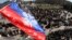 The flag of the so-called "Donetsk People's Republic" flies above a barricade and a crowd gathered in front of the Donetsk regional administration building, which is being held by pro-Russian militants. 