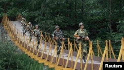 Indian border guards patrol on a footbridge built over a stream near the Line of Control (LoC), a cease-fire boundary that divides Kashmir between India and Pakistan. (file photo)