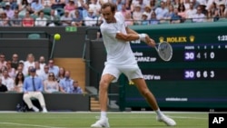Daniil Medvedev plays a return to Spain's Carlos Alcaraz during a men's singles match at Wimbledon in London in July 2021.