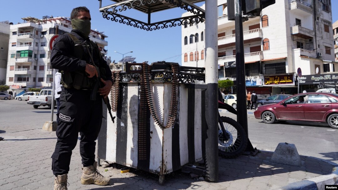 A member of the Syrian security forces stands guard after hundreds were killed in deadly violence in Latakia.