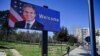 A man walks past a billboard depicting U.S. Secretary of State Antony Blinken displayed in Tirana on February 15.