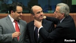 Spanish Economy Minister Luis de Guindos (center) jokes with Luxembourg Prime Minister and then-Eurogroup Chairman Jean-Claude Juncker (right) at a meeting in March 2012.