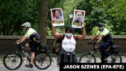 Demonstrantica drži dva znaka jedan za Breonnu Taylor, a drugi za Georgea Floyda dok demonstrira u New Yorku, 11. juni 2020.