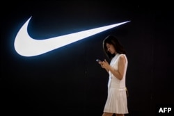 Nike дүкенінің алдынан өтіп бара жатқан тұрғын. Пекин, 2 маусым 2021 жыл.