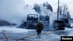 A firefighter walks in front of trucks destroyed during Russian drone and missile strikes on Kyiv on January 24.