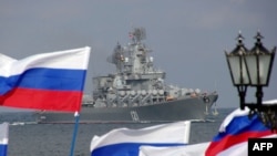 Russia supporters wave flags as a ship of Russia's Black Sea Fleet arrives in Crimea, Ukraine.