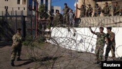 Vojnici i policajci osiguravaju područje dok zatvaraju cestu koja vodi do američke ambasade bodljikavom žicom i barikadama, u Awkaru, sjeverno od Bejruta, septembra 2013.