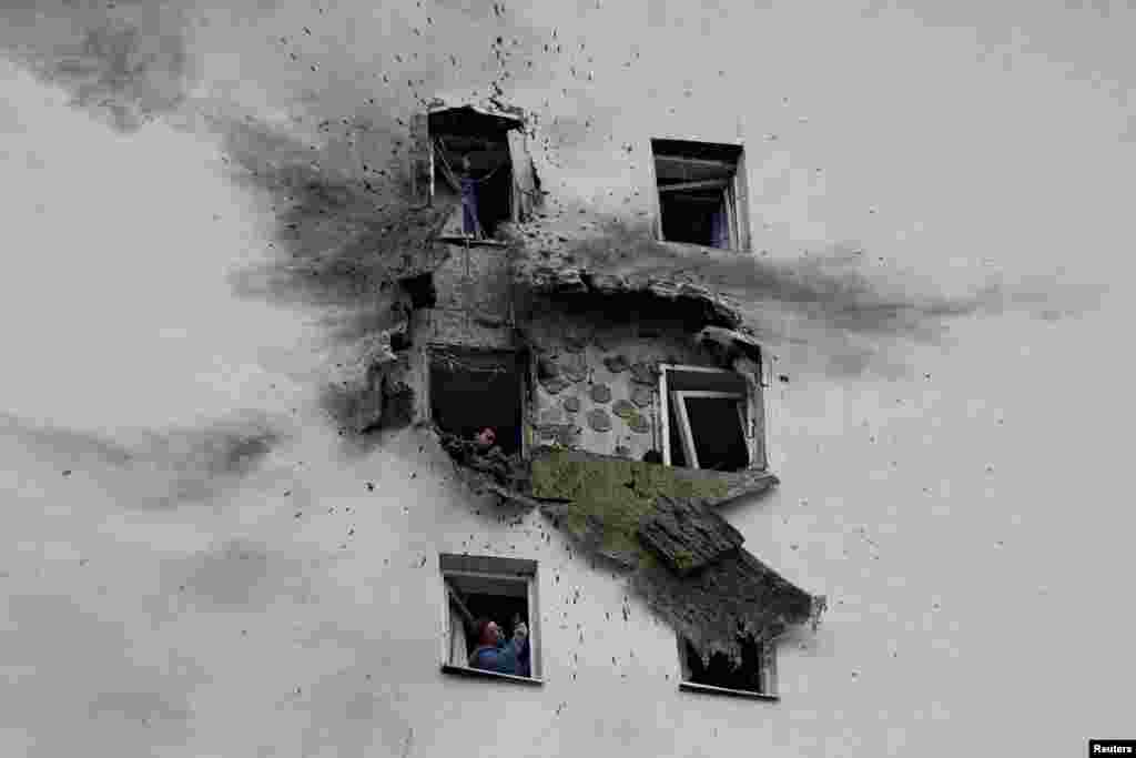 People look through the windows of a residential building in Moscow on March 11 that was struck by what local authorities described as a Ukrainian drone.Photo by Reuters.