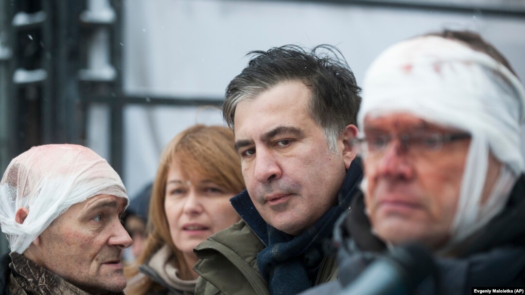 Former Georgian President Mikheil Saakashvili (center) speaks to people wounded during clashes with police in Kyiv on December 6.