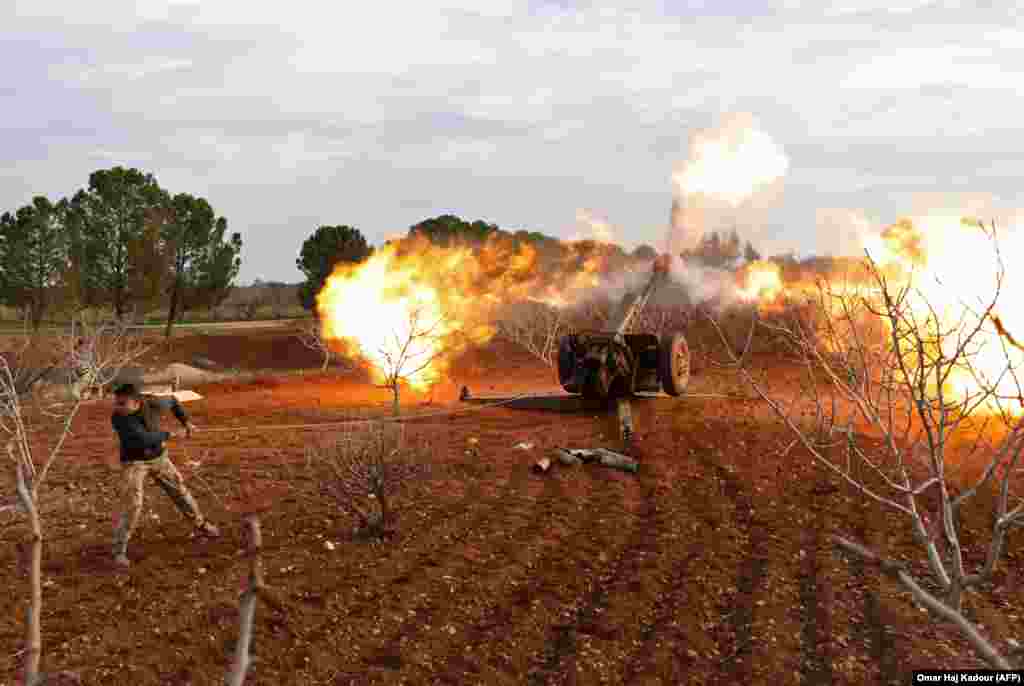 An opposition fighter fires artillery from a village near Al-Tamanah during ongoing battles with government forces in Syria's Idlib Province. (AFP/Omar Haj Kadour)