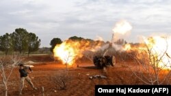 An opposition fighter fires a gun from a village near al-Tamanah during ongoing battles with government forces in Syria's Idlib province, January 11, 2018