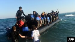 Migrants and refugees board a dinghy to travel to the Greek island of Chios from Cesme in the Turkish province of Izmir, November 4, 2015. 