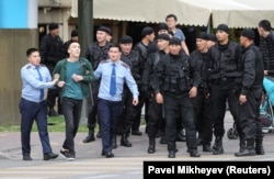 Полиция адамдардың бірін әкетіп барады. Алматы, 12 маусым 2019 жыл.