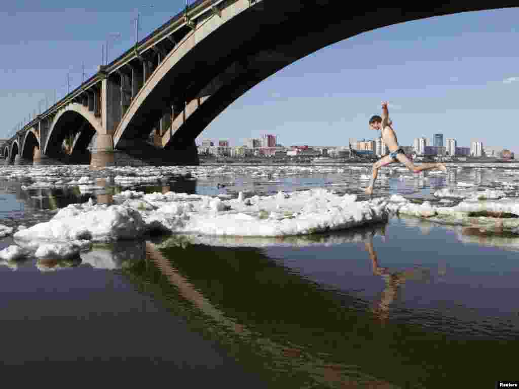 A member of a local rock-climbing club jumps on floating ice during an ice drift on the Yenisei River in the Russian city of Krasnoyarsk on April 18.Photo by Ilya Naymushin for Reuters