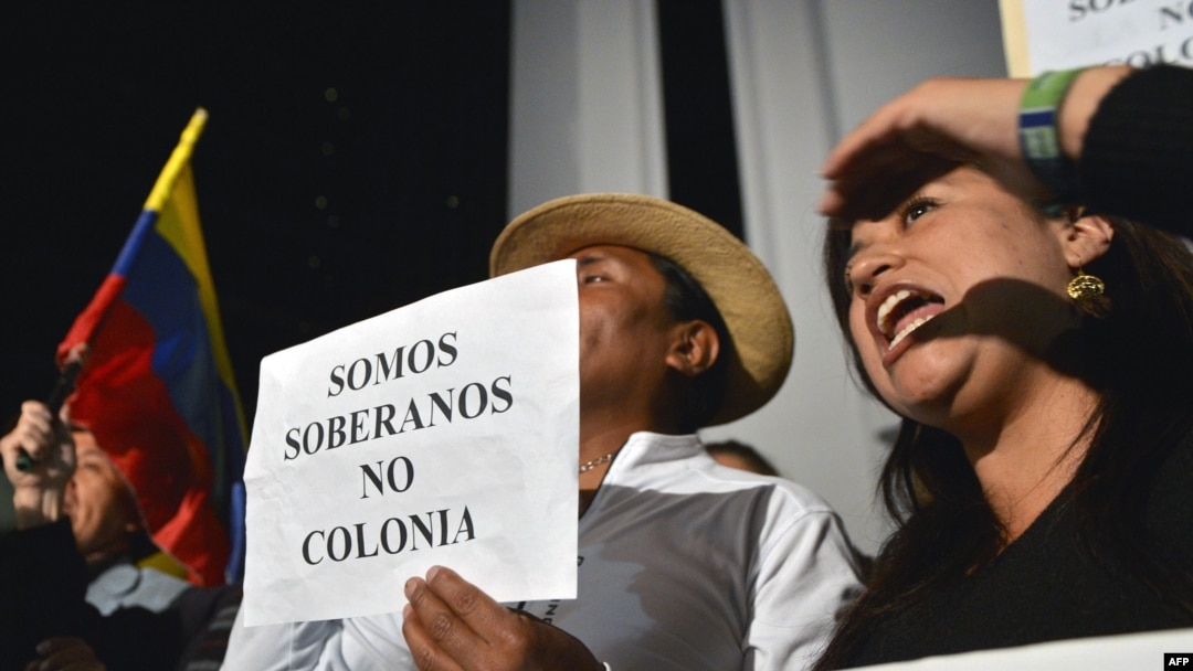 Demonstrators hold a sign reading "We are sovereign, not colonies," as they shout slogans outside the British Embassy in Quito on August 15.