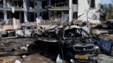 A view of burnt cars and a damaged building at an impact site following Iran's missile strike on Israel on June 20. 