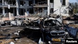 A view of burnt cars and a damaged building at an impact site following Iran's missile strike on Israel on June 20. 