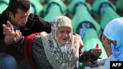 Bosnians mourn over the coffin of a relative during the preparation for a mass burial at the Srebrenica-Potocari Memorial and Cemetery in 2010.