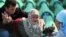 Bosnians mourn over the coffin of a relative during the preparation for a mass burial at the Srebrenica-Potocari Memorial and Cemetery in 2010.