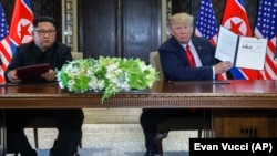 Паўночнакарэйскі лідэр Кім Чэн Ын (зьлева) і прэзыдэнт ЗША Дональд Трамп. 12 чэрвеня 2018 году