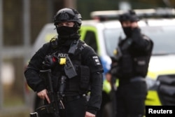 Armed police officers stand guards on a road outside the perimeter of the RAF Fairford airbase on September 28.