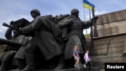 Copii, jucându-se pe un monument din epoca sovietică consacrat Celui De-al Doilea Război Mondial, la Muzeul Național de Istorie al Ucrainei 