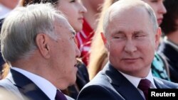 Президент России Владимир Путин смотрит на бывшего президента Нурсултана Назарбаева, прибывшего в Москву и участвующего в торжествах по случаю Дня города. Сентябрь 2019 года