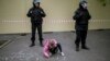 A young girl writes "I'm for the park" on the asphalt in front of a fence designed to block demonstrators protesting plans to construct a cathedral in a park in Yekaterinburg on May 16.