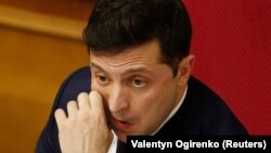 Ukrainian President Volodymyr Zelenskiy reacts during a parliamentary session in Kyiv on March 4, which ushered in a major cabinet reshuffle. 