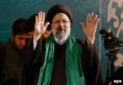 Iranian conservative presidential candidate Ebrahim Raisi waves to supporters on the campaign trail.