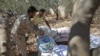 Syrian rebel fighters in Idlib Province pile up sandbags as they prepare for a government assault.