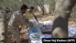 Syrian rebel fighters in Idlib Province pile up sandbags as they prepare for a government assault.