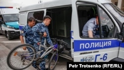 Полиция алаң маңында ұстаған жергілікті тұрғын Арман Абдуллахановтың велосипедін көлікке салып жатыр. Алматы, 10 маусым 2019 жыл.