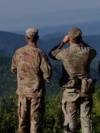 Paqeruajtës të NATO-s duke vëzhguar në Kosovë.