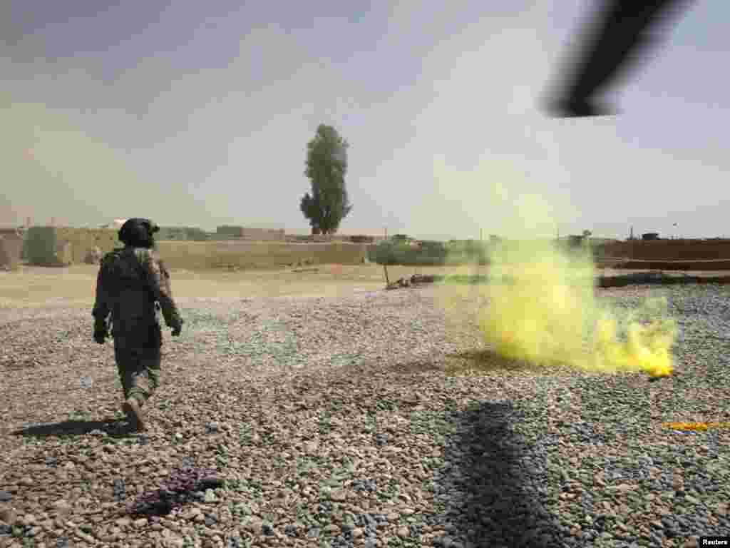 A U.S. Army medic walks past a smoke grenade after landing in a medevac helicopter to pick up a wounded Marine near the town of Marjah in Helmand Province on August 19. Photo by Bob Strong for Reuters