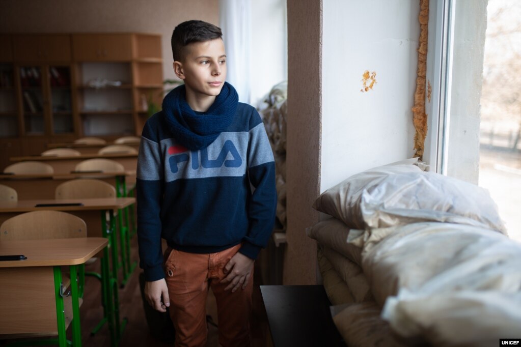 Школярі на сході Україні страждають від того, що протягом перших місяців 2019 року кількість атак на школи зросла в чотири рази в порівнянні з аналогічним періодом попереднього року. Як зазначають у Дитячому фонді ООН (ЮНІСЕФ), збільшення числа атак посилює психологічні травми у школярів, а також створює для них ризики фізичних травм або смерті. За даними ЮНІСЕФ, у період із січня до квітня 2019 року зафіксовано 12 атак на школи, тоді як за аналогічний період минулого року &ndash; три такі випадки. На фото 12-річний Гриша &ndash; він учень школи у Мар&rsquo;їнці, що на Донеччині. &laquo;Ми звикли до цих звуків, і ми більше не боїмося&raquo;, &ndash; розповідає Гриша про обстріли і додає: &laquo;Але нам не подобається, що ми не можемо вийти на вулицю. Ми повертаємося додому зі школи і після 16-ї &ndash; 17-ї нікуди не виходимо&raquo;.