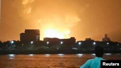 A man watches Indian Navy submarine "INS Sindhurakshak" on fire in Mumbai late on August 13.